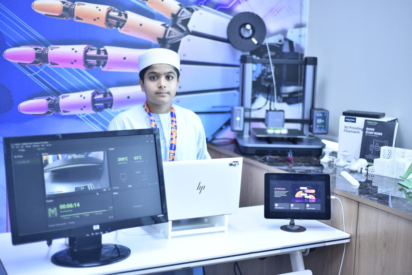 Student running a live 3D print with 3D printed models on display