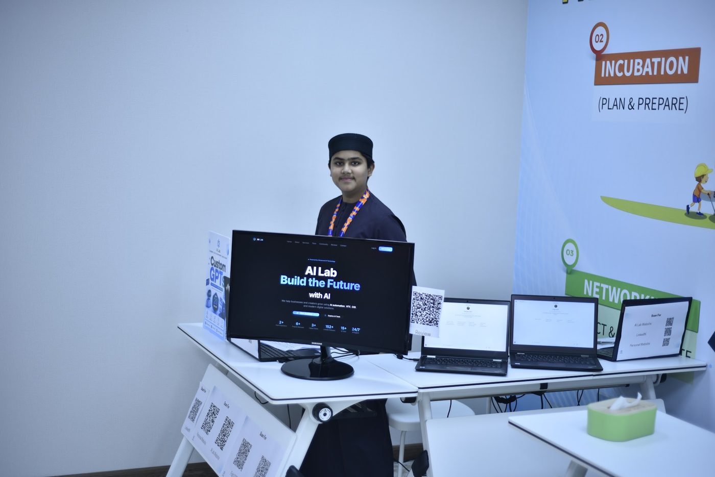 Student presenting his AI Lab startup and custom GPT tools at his booth