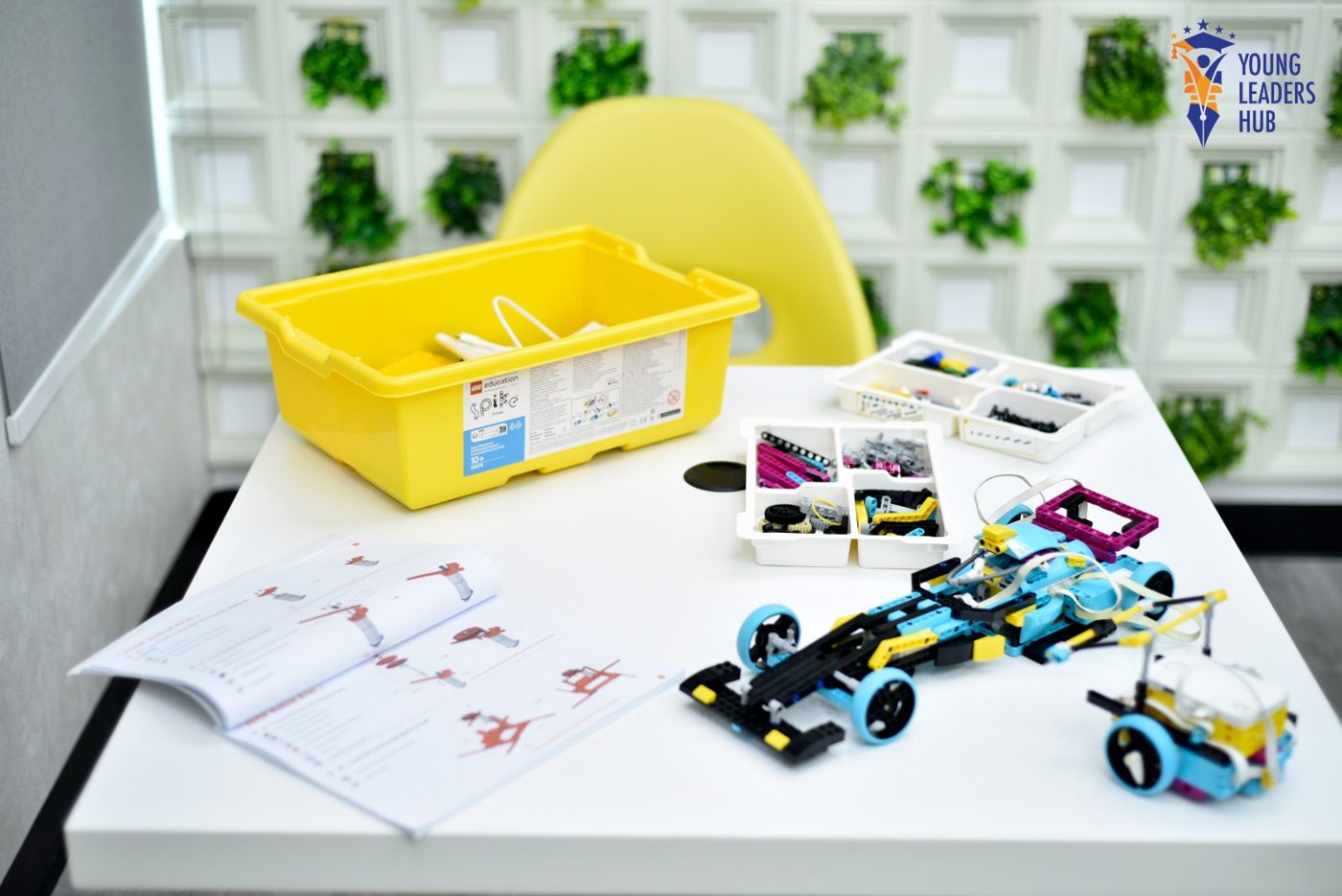 Robot car built from a LEGO SPIKE robotics kit with sensors and instruction booklet