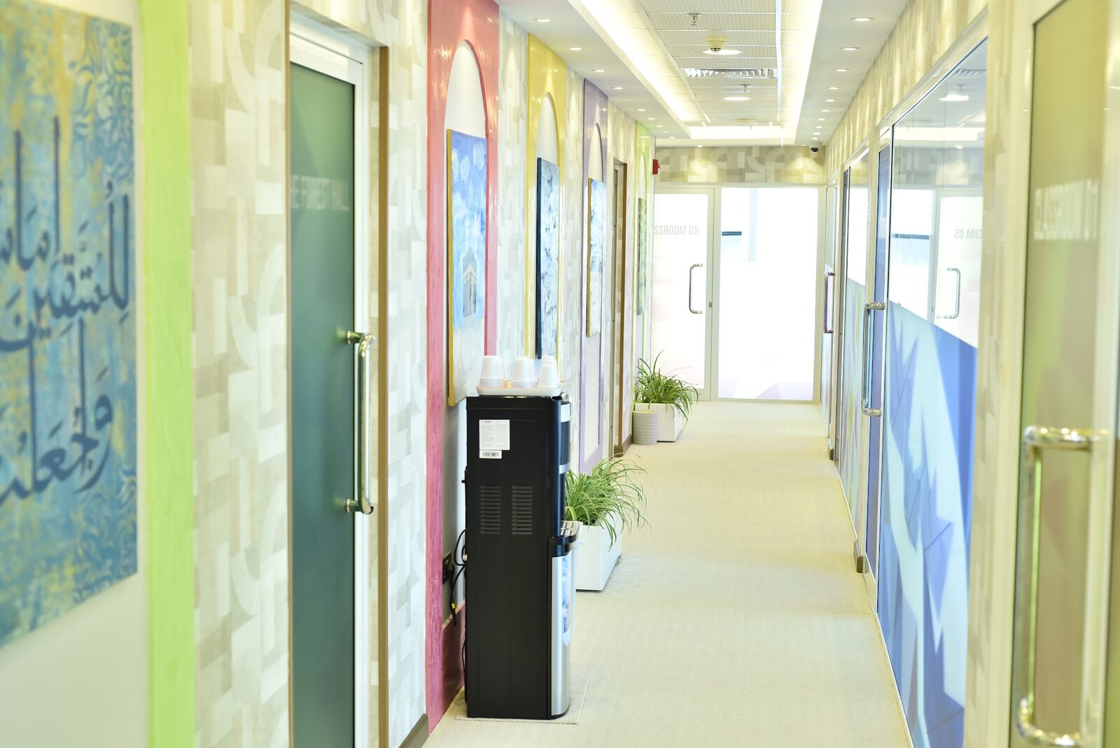 Corridor with Arabic calligraphy artwork and a water cooler