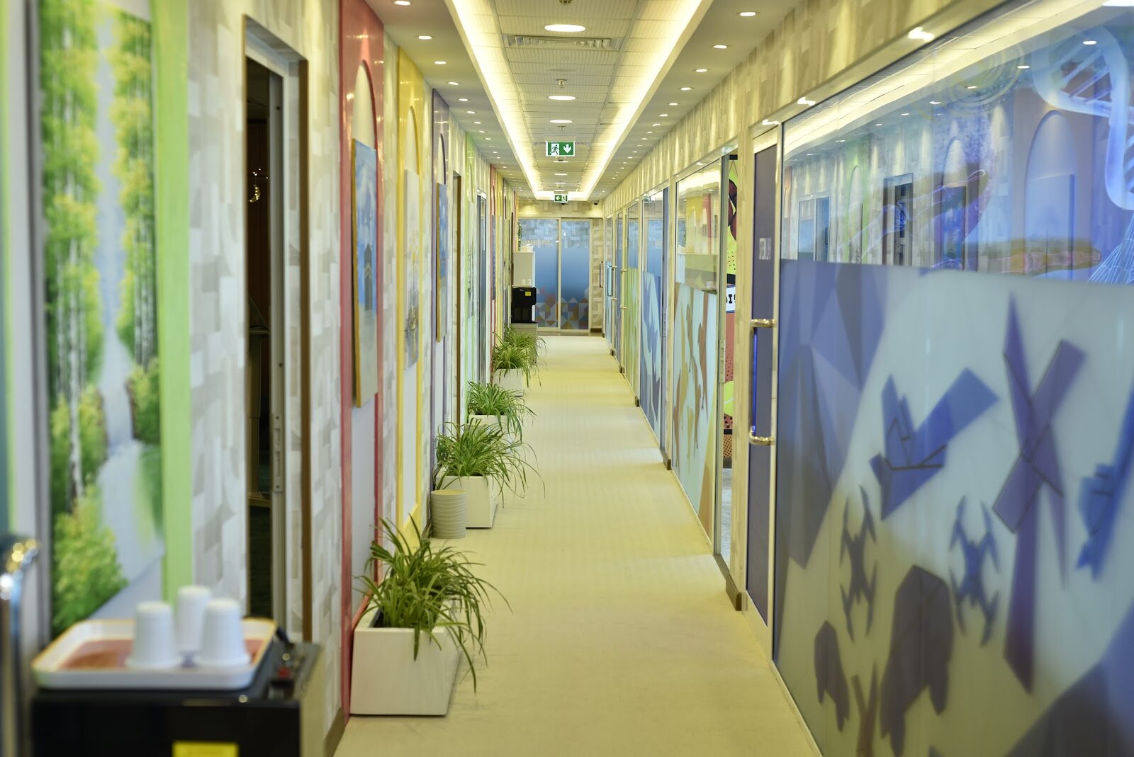 Long corridor lined with colourful arched classroom doors