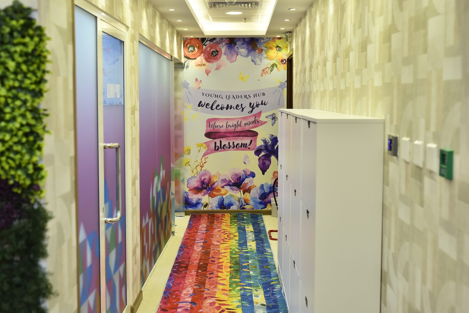 Welcome corridor with floral mural, lockers and a rainbow rug