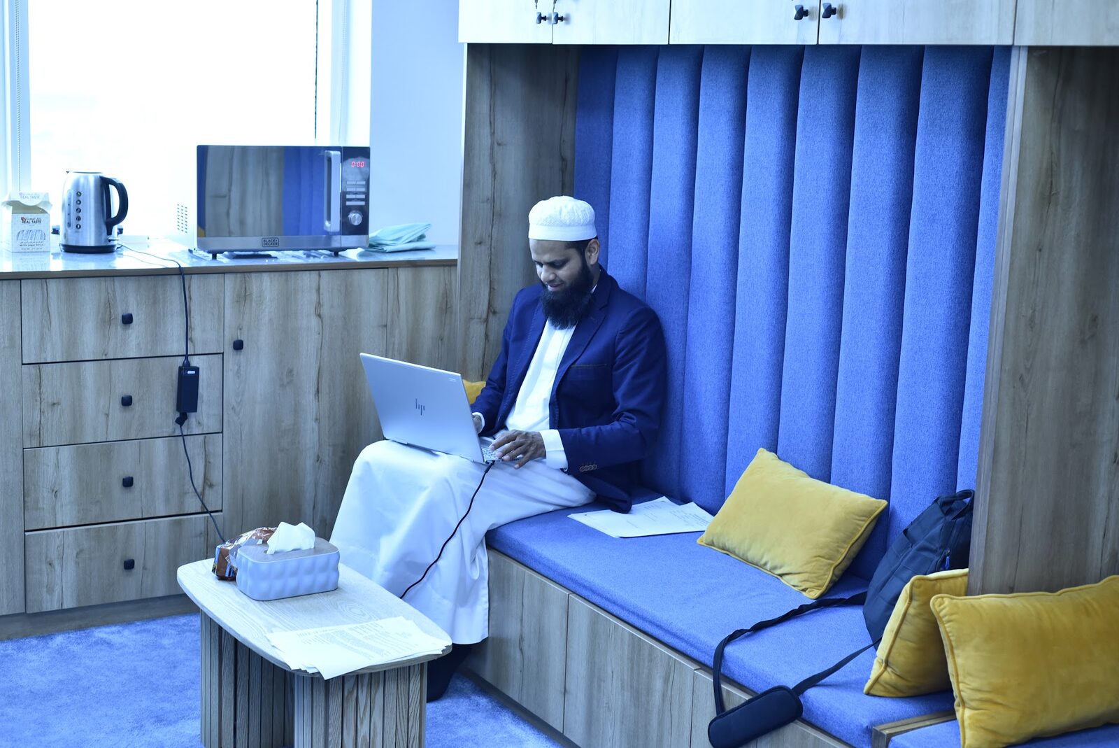 Faculty Lounge seating nook with a mentor working on a laptop