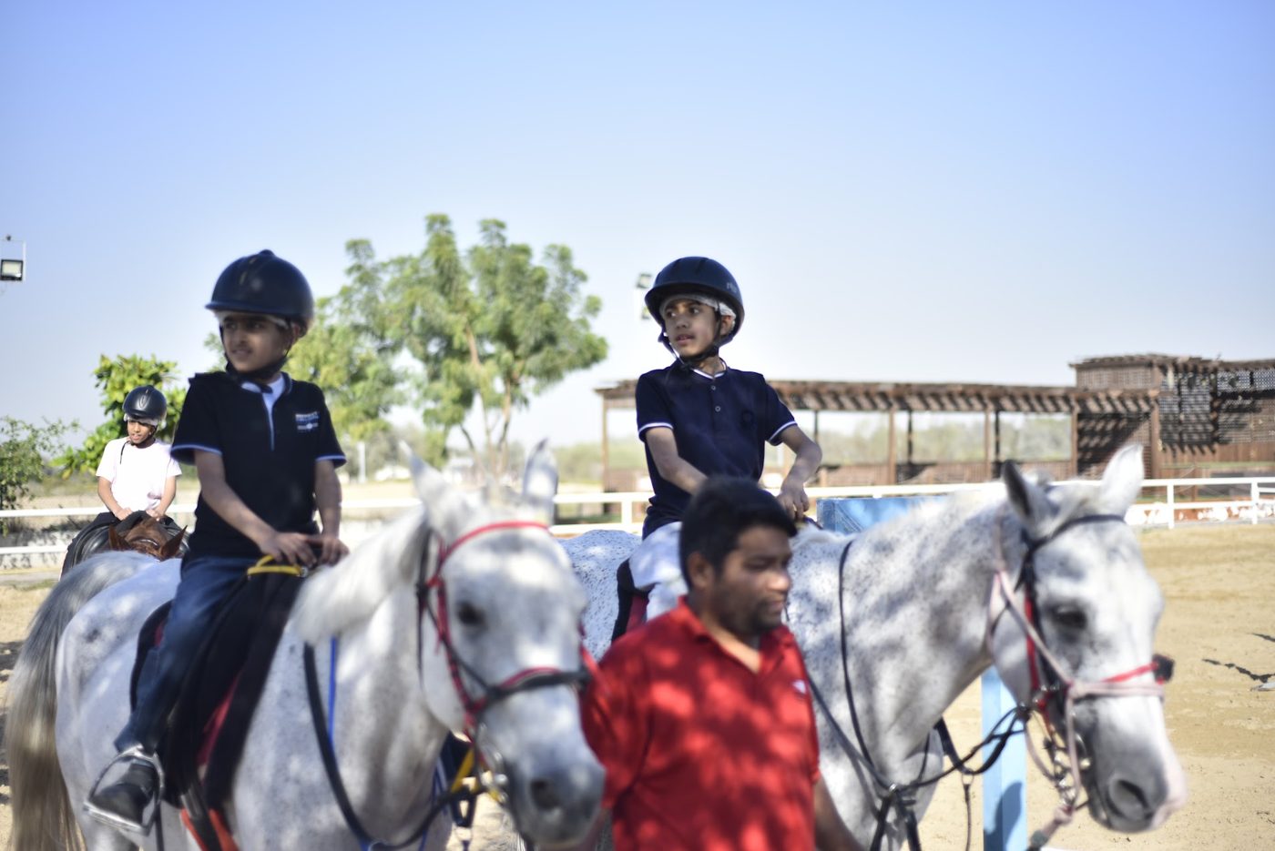 Student waving while horse riding on a field trip