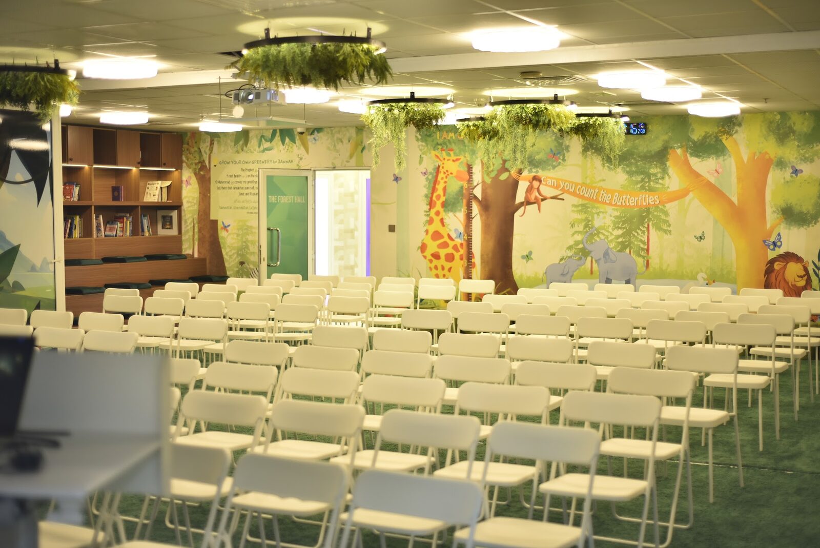 Forest Hall main assembly hall with jungle mural and rows of chairs