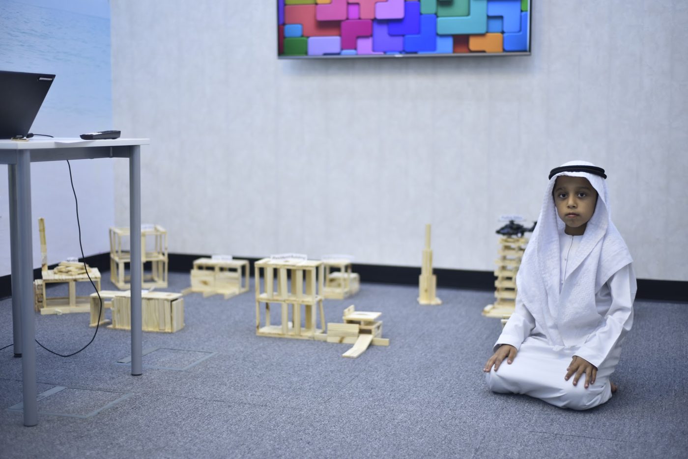 Student presenting a hand-built eco-friendly smart city model with towers and model buildings