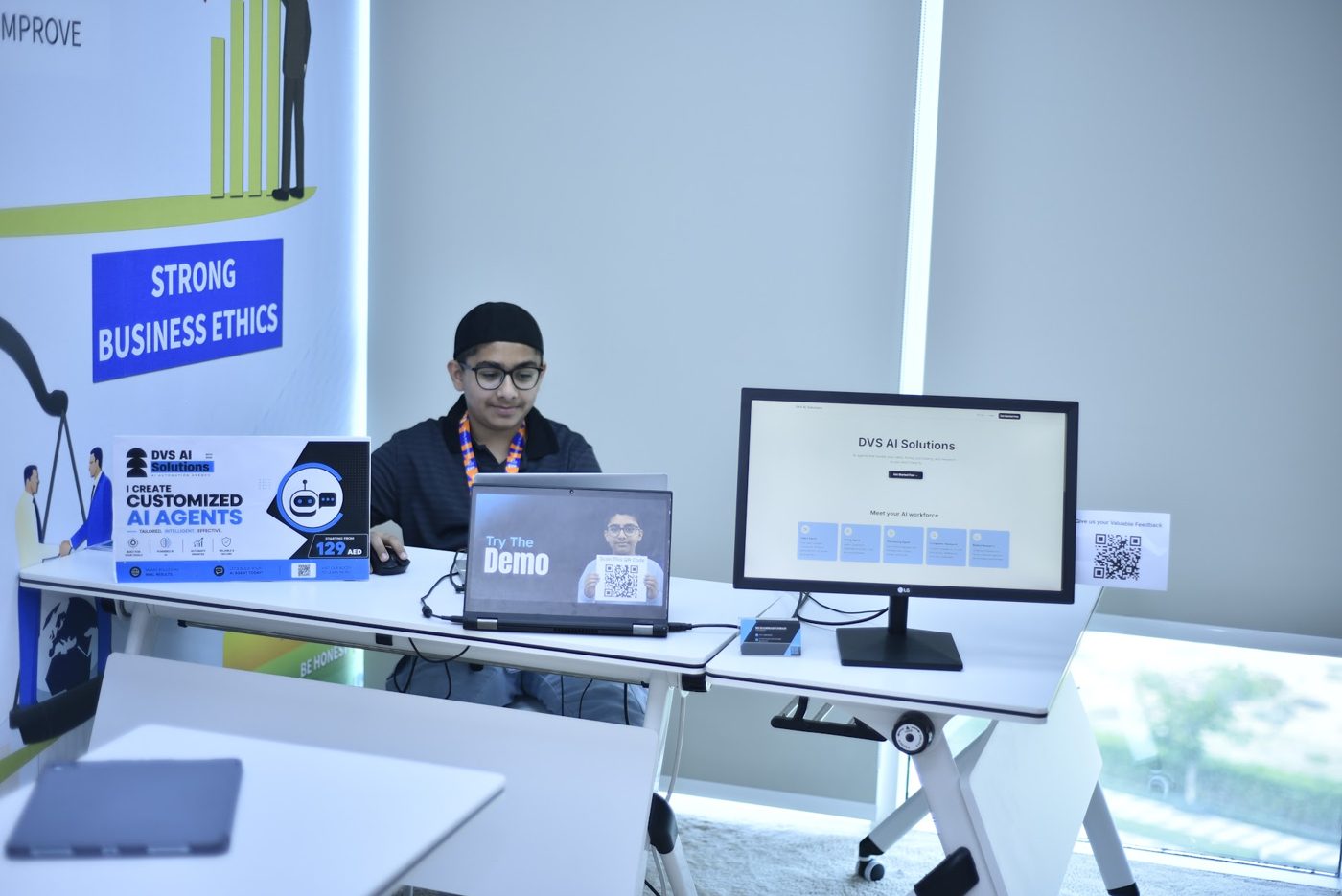 Student marketing his AI agents business with branded signage, a demo and QR codes