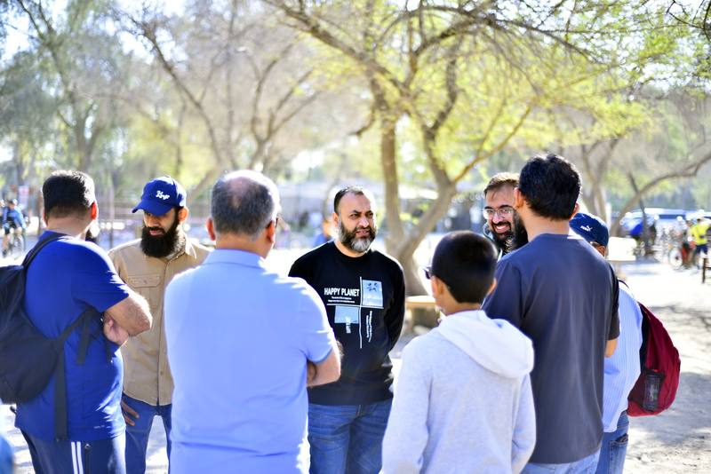 Fathers and sons gathered in a circle for the morning briefing under the trees