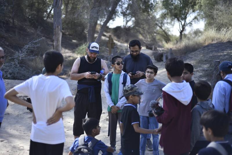 Fathers and sons gathered on the trail checking the route together
