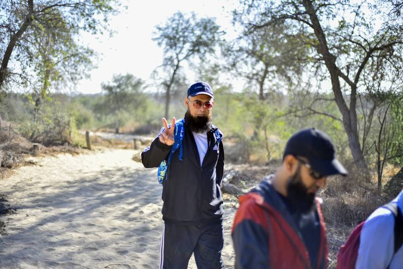 Group leader giving a peace sign on the sandy trail
