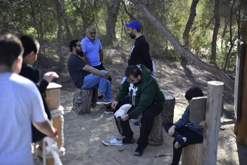 Group resting on tree-stump seats in the shade