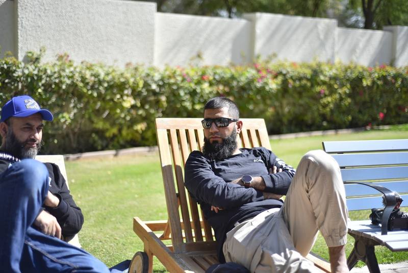 Two fathers relaxing on wooden loungers on the lawn