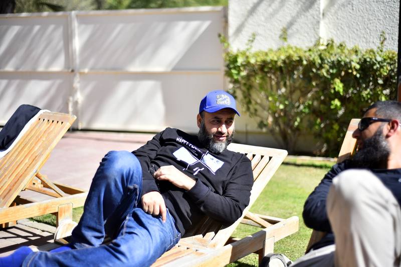 Father resting on a lounger chatting in the sunshine