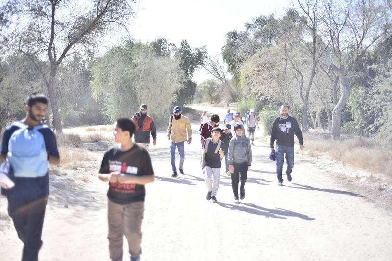 Group walking the desert trail in the morning light