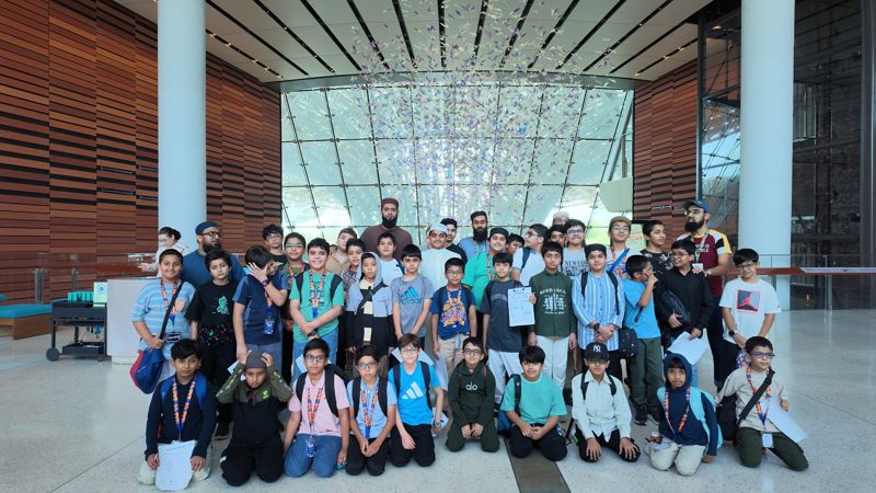 Students and teachers posing for a group photo in the TERRA pavilion lobby