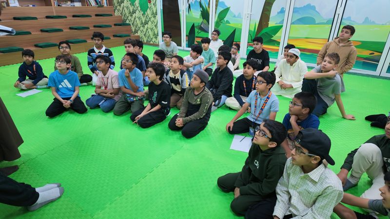 Students seated on the mat for a briefing before the field trip