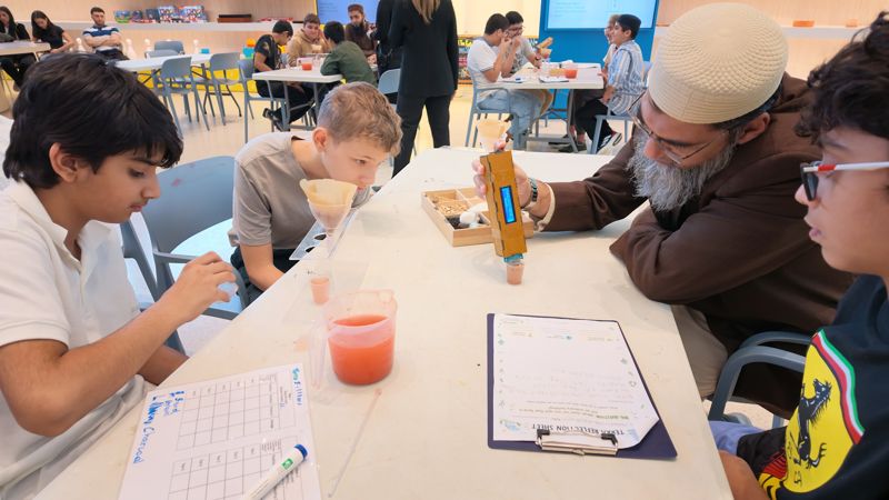 Teacher measuring water clarity with students