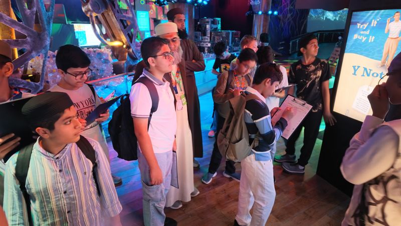 Students filling in reflection sheets at an exhibit