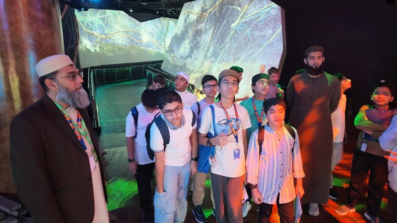 Teachers and students in front of a forest projection