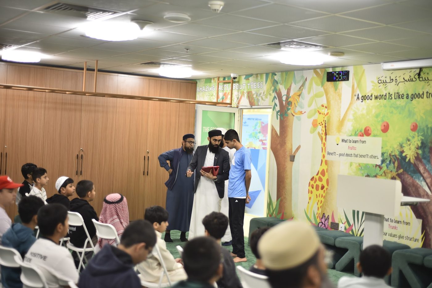 Abdullah Taimoor and a colleague speaking with a student in the Forest Hall