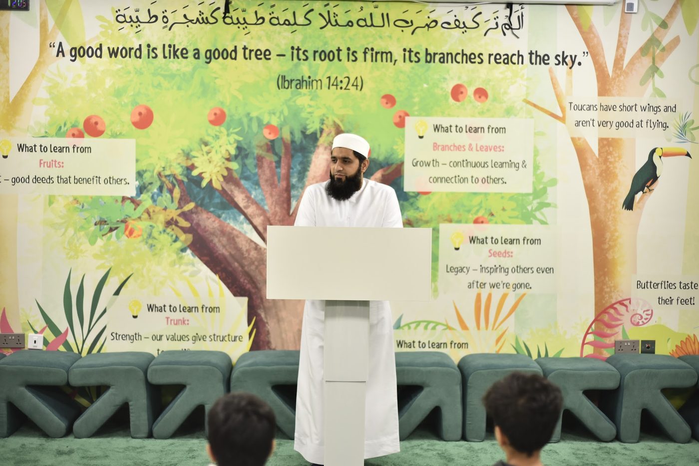 Speaker mid-address at the podium in the Forest Hall