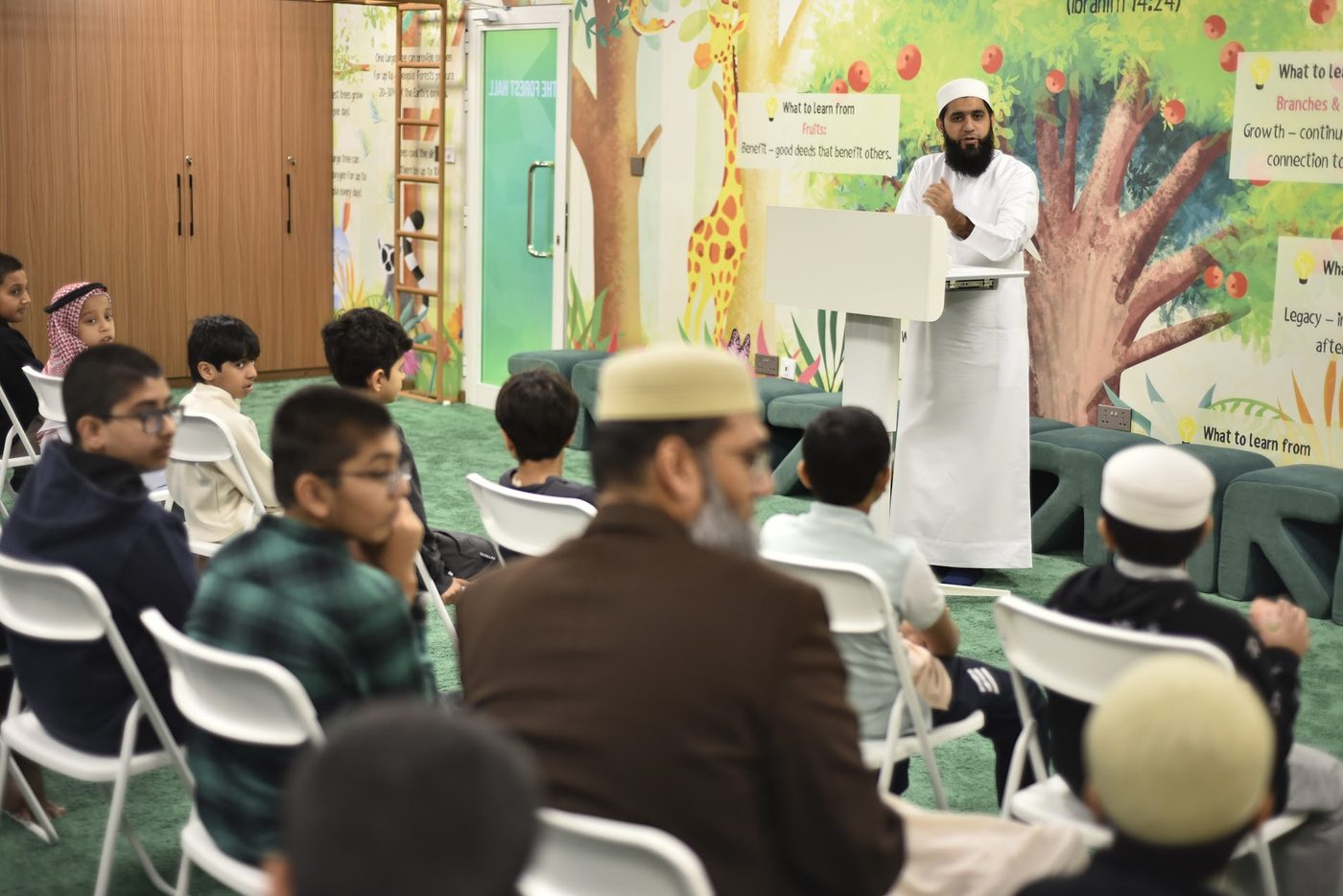 Speaker pausing mid-talk at the podium in the Forest Hall