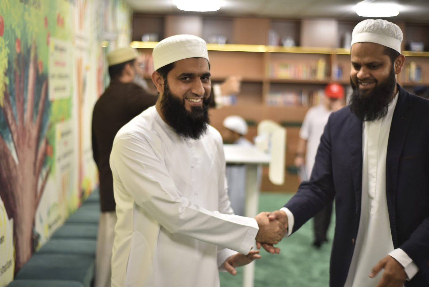 Two attendees greeting each other with a handshake