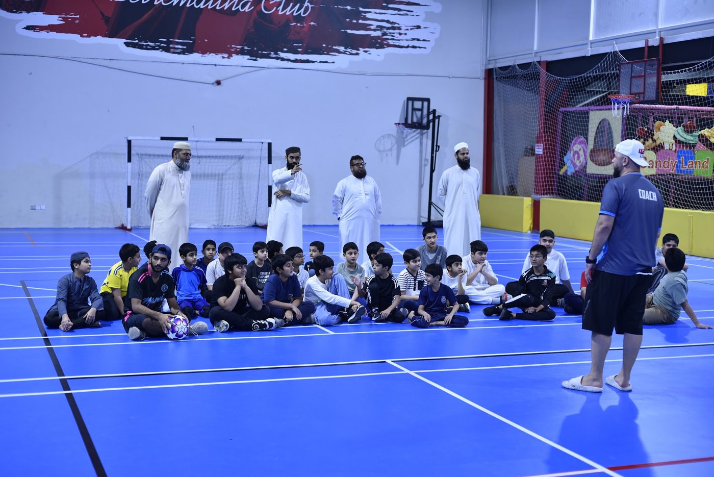Coach briefing students before a sports session in the indoor hall