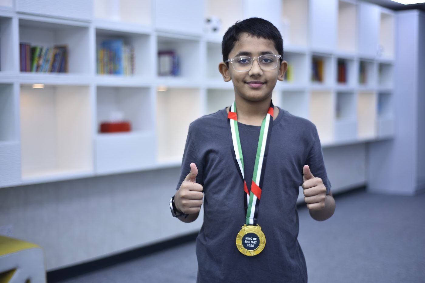 Competitor wearing a King of the Mat 2025 gold medal, giving two thumbs up