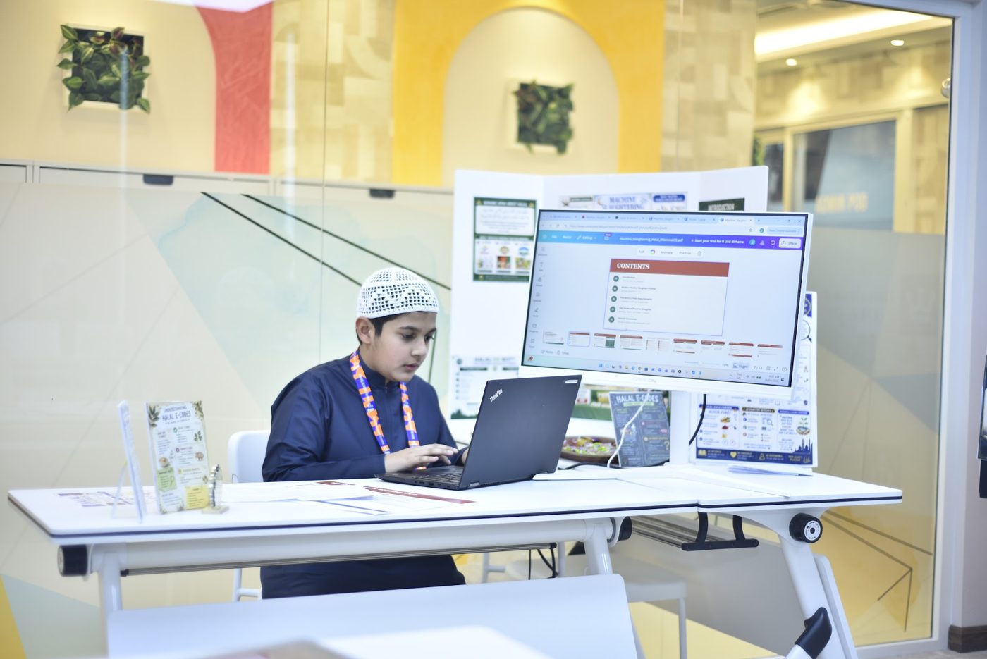 Student studying and presenting his research project on a laptop
