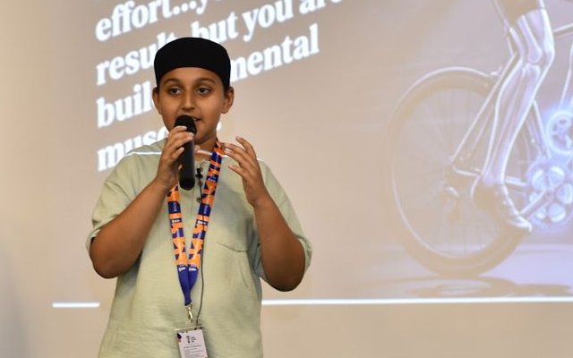 Student giving a talk with a microphone in front of an audience