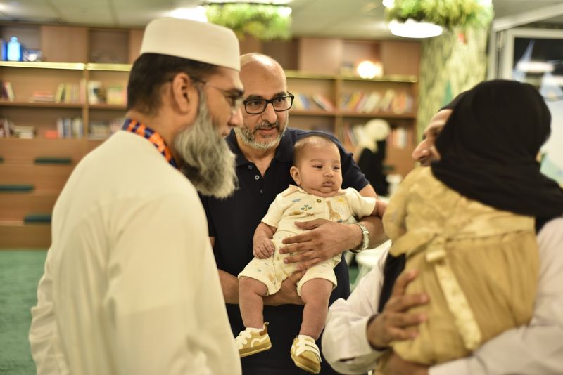 Families greeting each other with a baby at the event