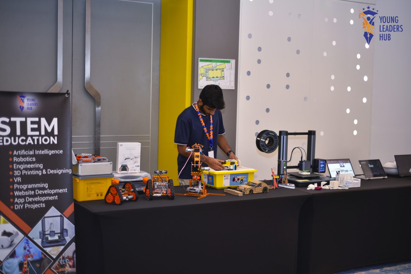 Student presenting his STEM booth with robots, a 3D printer and hands-on builds