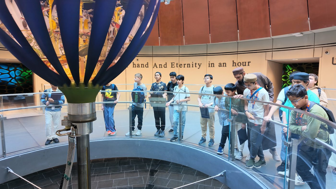 Students and their teacher exploring a museum exhibit on a field trip